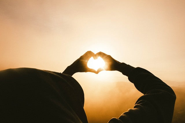 pareja dibujando un corazon en el cielo