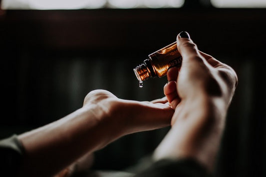 persona aplicando aceite en sus manos en fondo negro