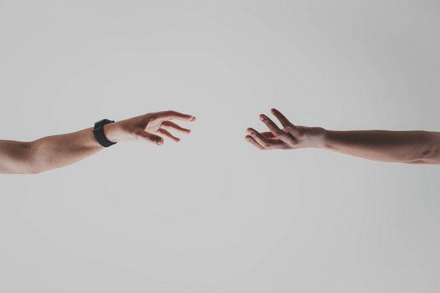 personas tomadasde la mano alejandose con un fondo gris