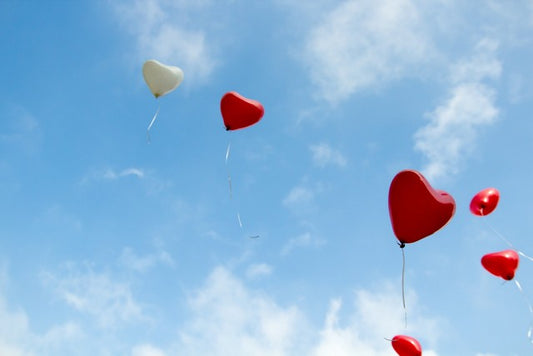 globos con forma de corazón elevándose en el cielo